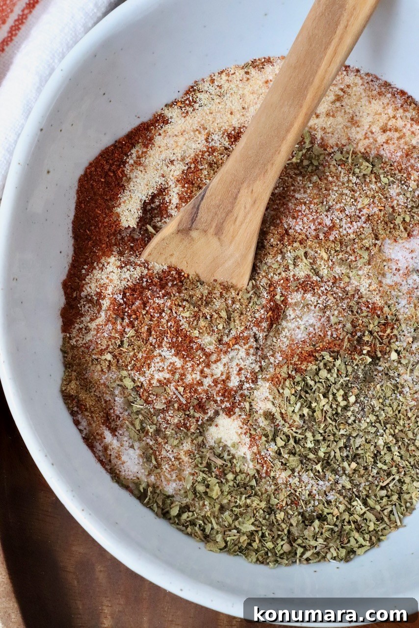 Authentic Carnitas Seasoning Recipe for Tender Pork 2 carnitas seasoning mixed together in a bowl with a wooden spoon