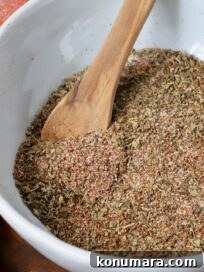 carnitas seasoning in a bowl with a wooden spoon