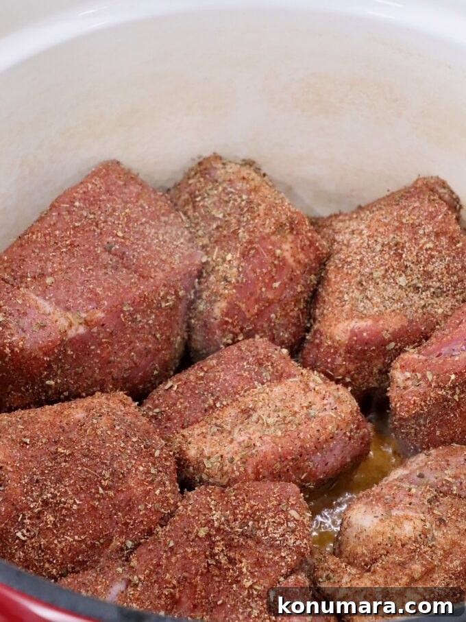 seasoned pieces of pork in a large cast iron dutch oven