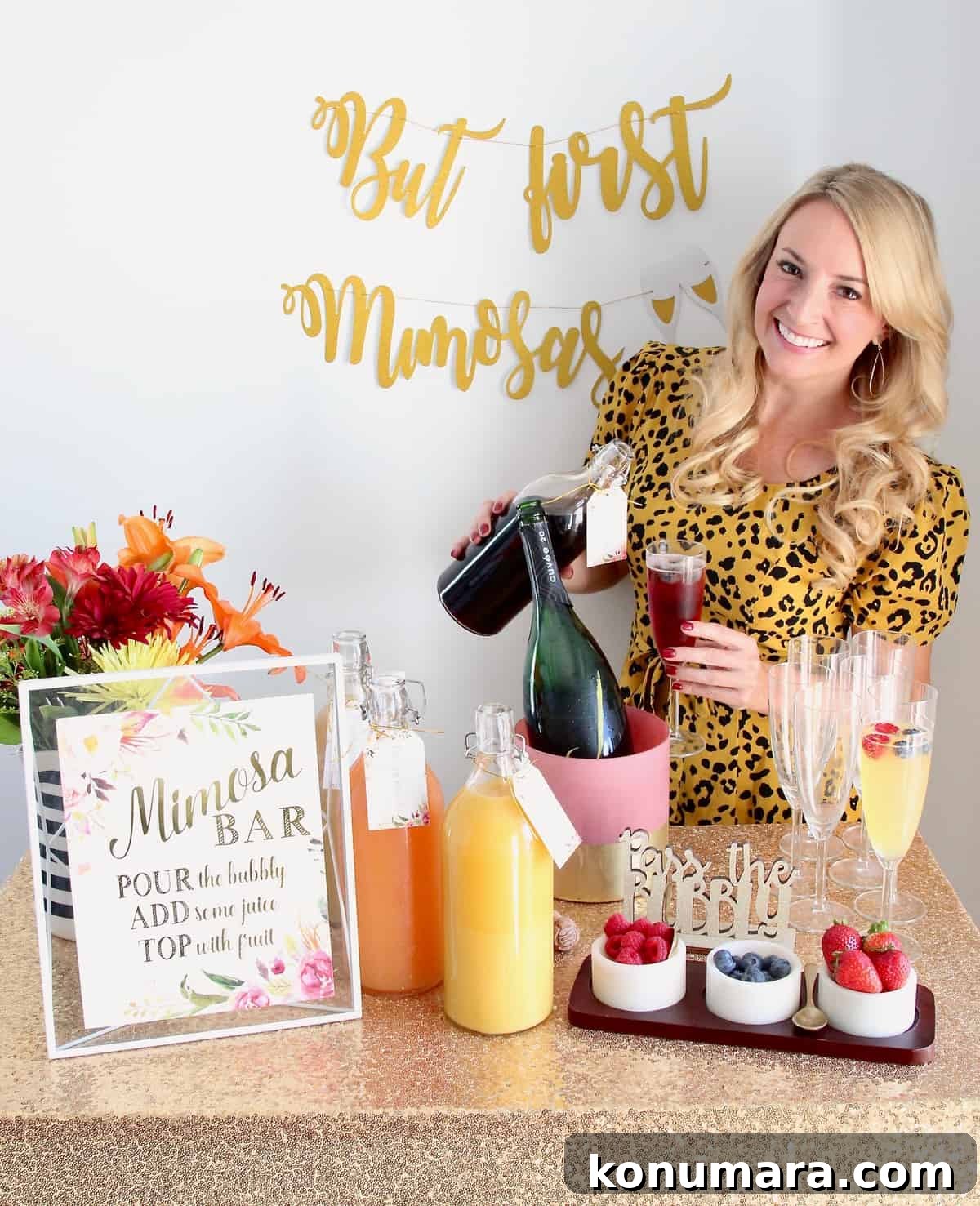 Woman pouring juice into a mimosa standing behind a mimosa bar