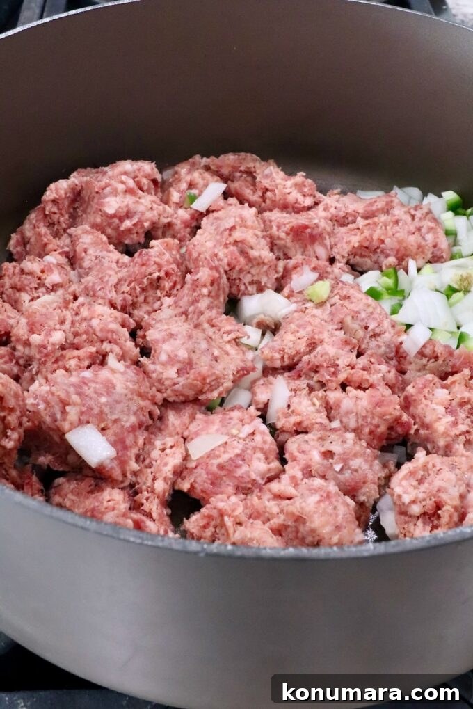 How to Make Smoked Queso Dip 4 Uncooked sausage in a large pot with diced onions and jalapenos
