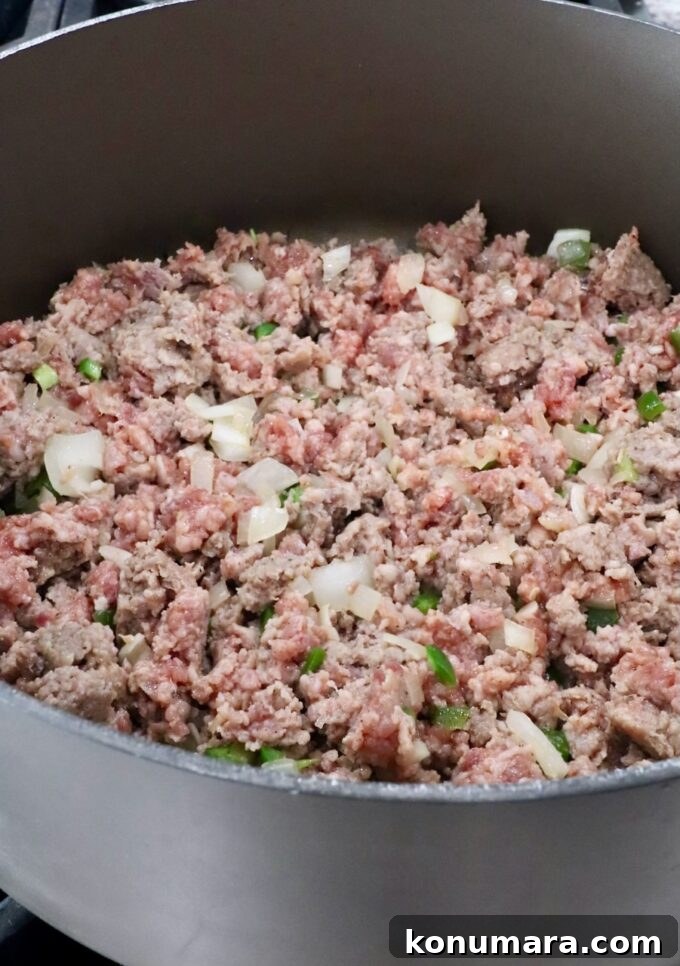 How to Make Smoked Queso Dip 5 Cooked sausage in a large pot with diced onions and jalapenos