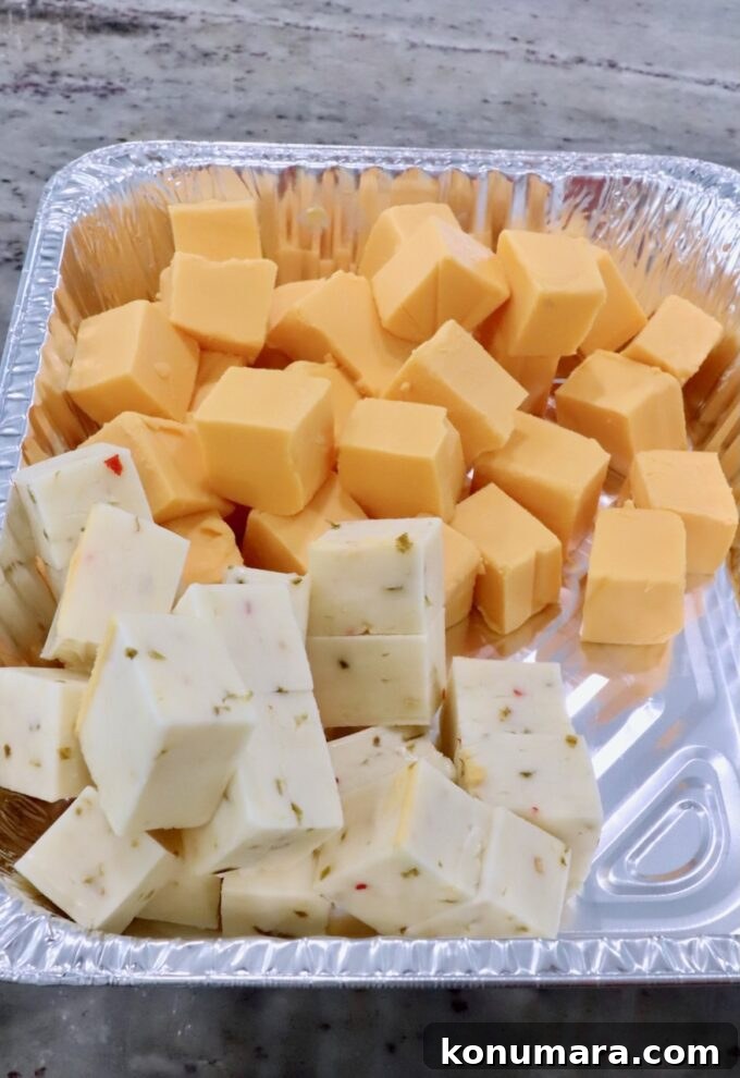 How to Make Smoked Queso Dip 6 Cubes of Velveeta cheese and pepper jack cheese in an aluminum foil pan