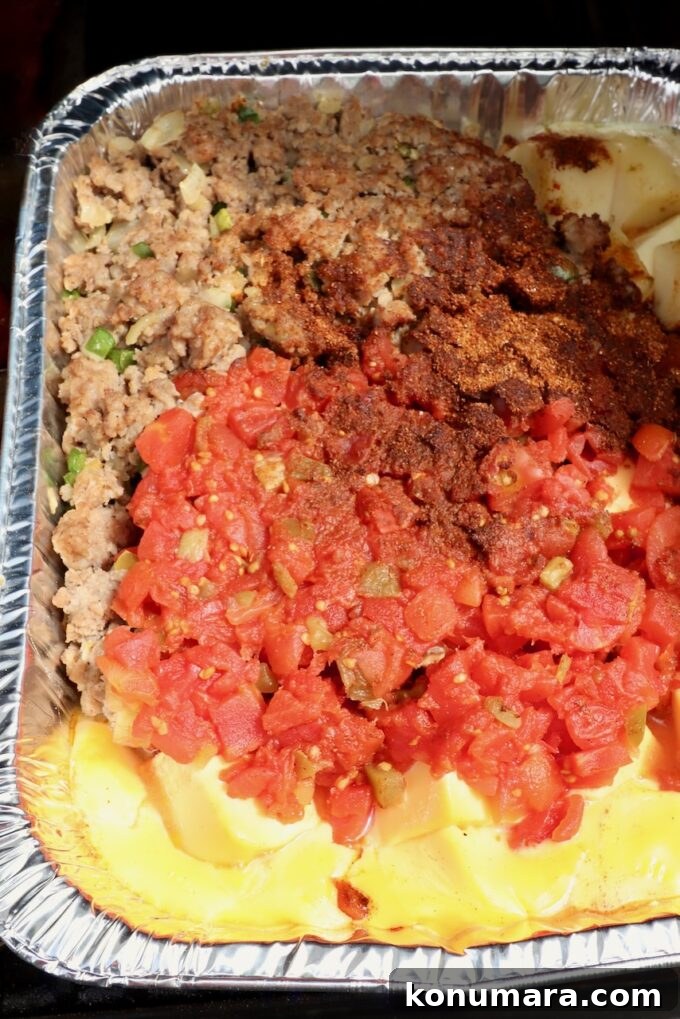 How to Make Smoked Queso Dip 8 Melted cheese, cooked, crumbled sausage, diced tomatoes and chili seasoning in an aluminum pan on a smoker