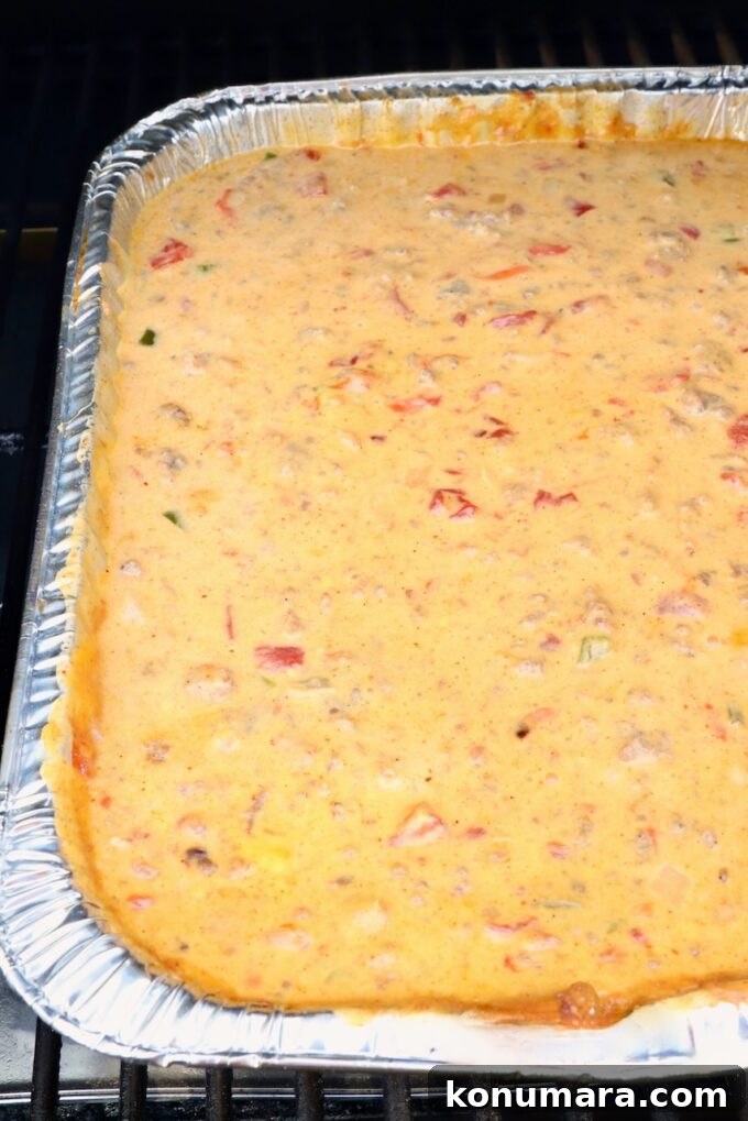 How to Make Smoked Queso Dip 9 Queso dip in an aluminum pan on a smoker