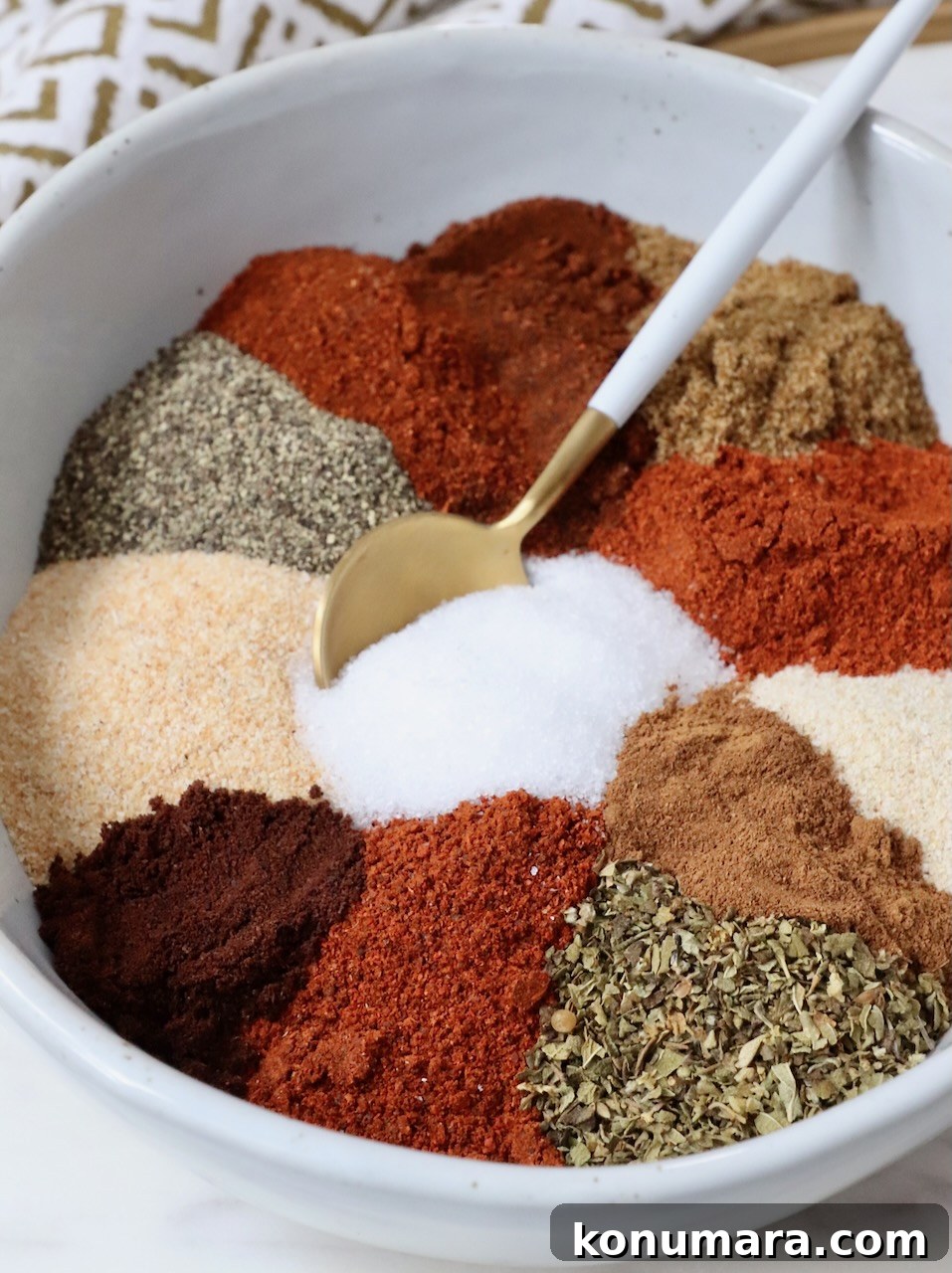 dried herbs and spices separated in a bowl with a spoon