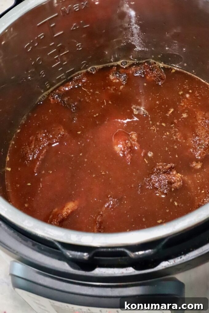 Instant Pot Beef Birria Tacos Recipe with Dipping Broth 7 beef covered in liquid in an Instant Pot