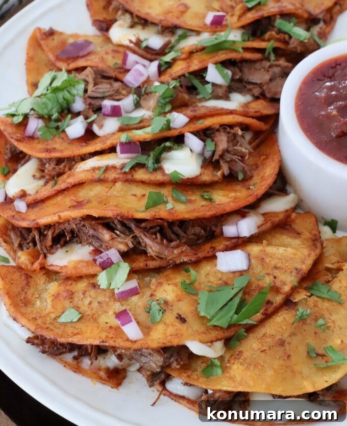 Instant Pot Beef Birria Tacos Recipe with Dipping Broth 8 quesabirria tacos on plate with side of tomato beef broth in a small bowl