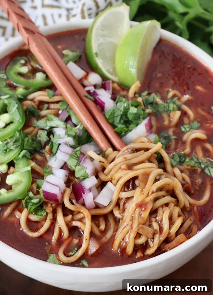 Instant Pot Beef Birria Tacos Recipe with Dipping Broth 9 cooked ramen noodles in beef broth in bowl topped with diced onions and sliced jalapenos