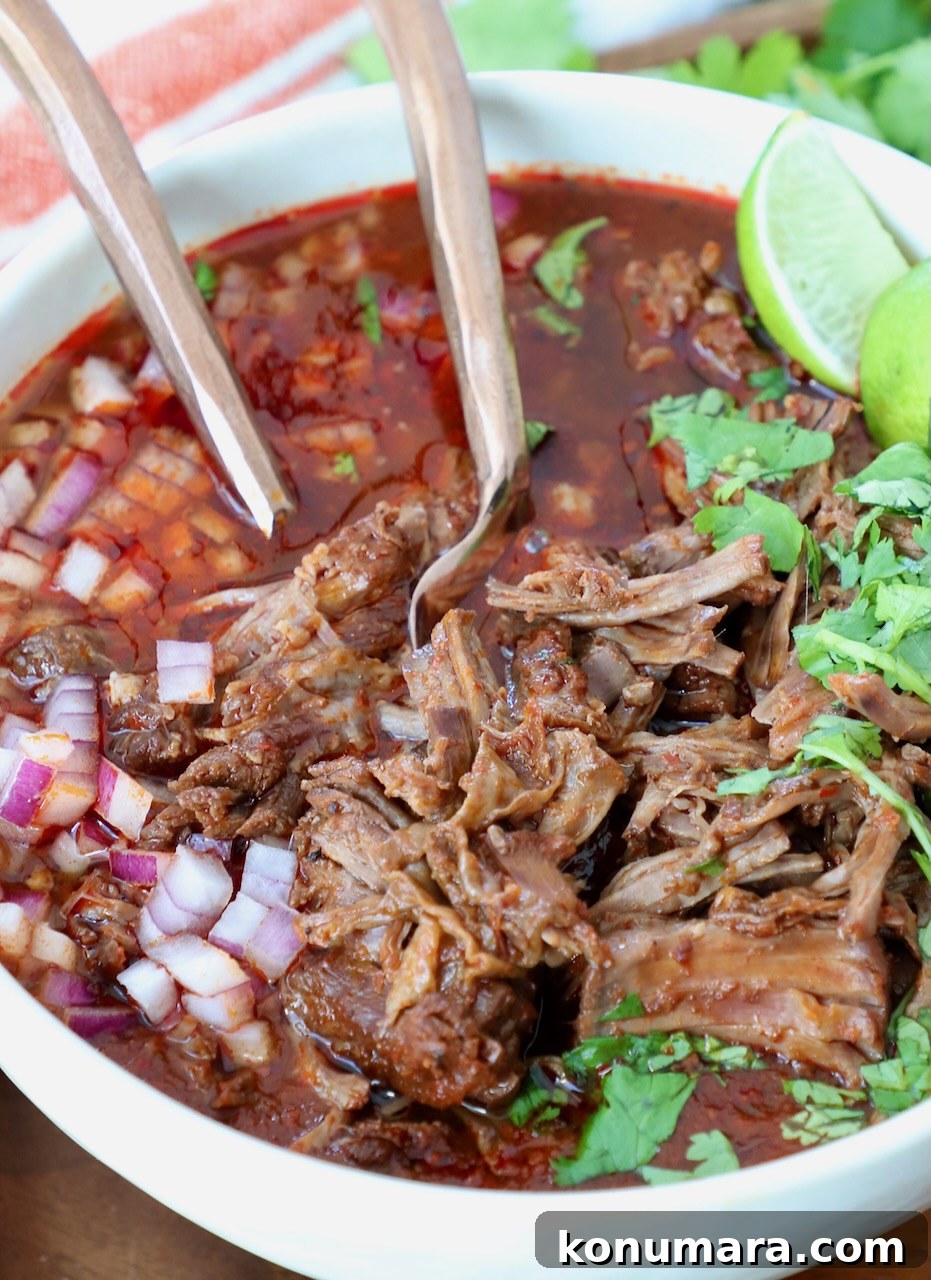 Instant Pot Beef Birria Tacos Recipe with Dipping Broth 10 shredded beef in birria broth in a bowl with forks