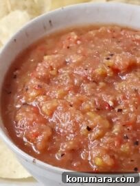 peach salsa in a bowl surrounded by tortilla chips