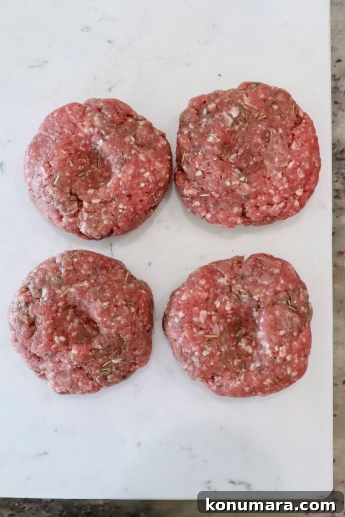 Grilled Mediterranean Lamb Burger with Mint Yogurt Sauce 4 lamb burger patties on a white cutting board