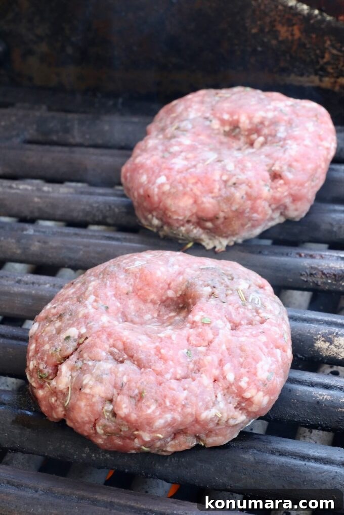 Grilled Mediterranean Lamb Burger with Mint Yogurt Sauce 5 raw lamb burger patties on a grill