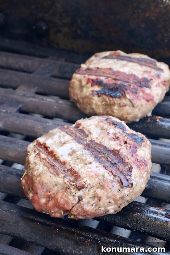 Grilled Mediterranean Lamb Burger with Mint Yogurt Sauce 6 cooked lamb burger patties on a grill