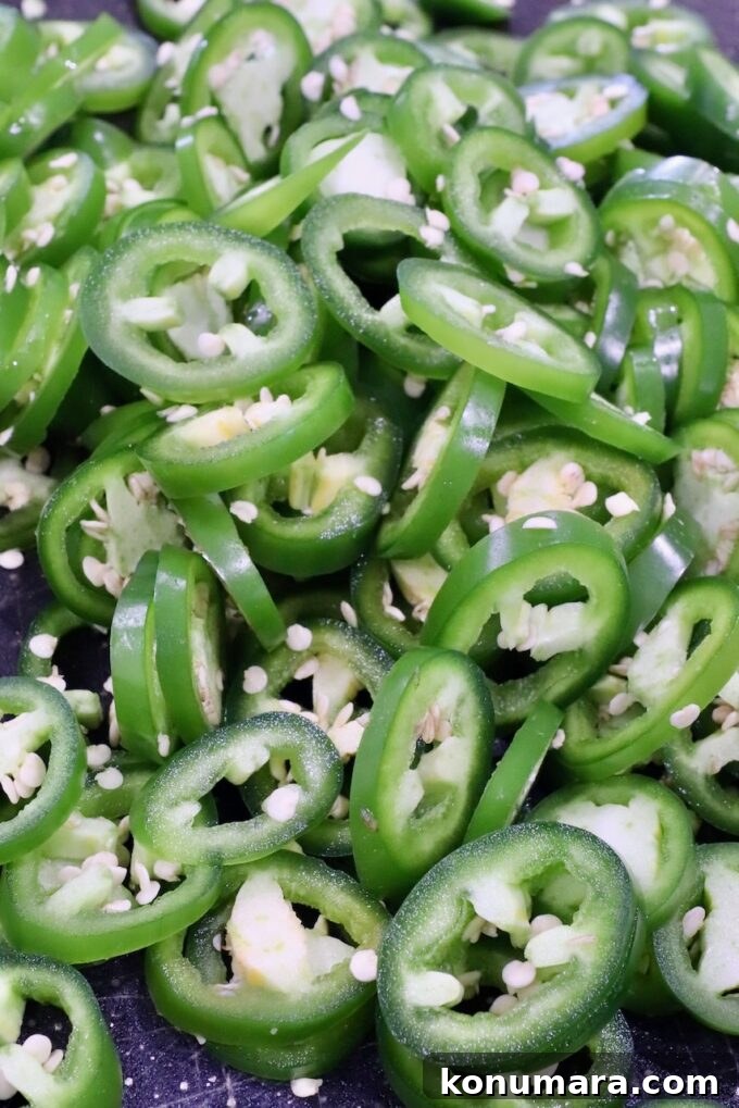 How to Make Sweet and Spicy Candied Jalapenos 4 sliced jalapenos on a cutting board