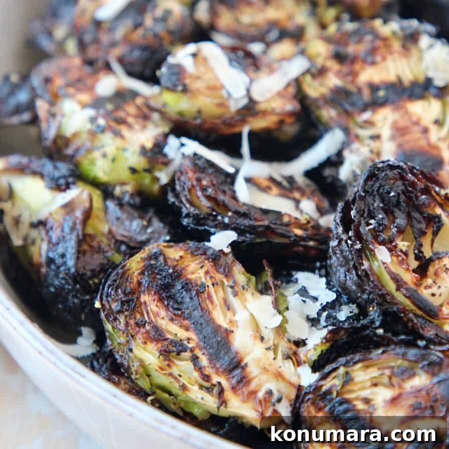 grilled brussels sprouts in bowl topped with grated parmesan cheese