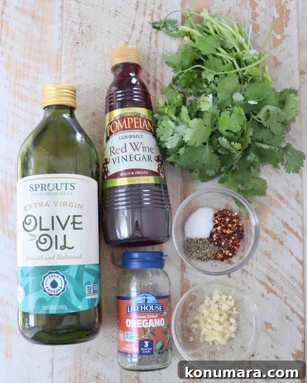 ingredients for cilantro chimichurri sauce on a white wood board