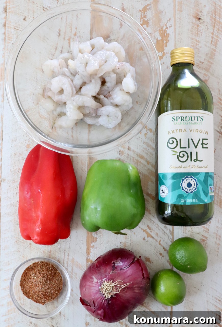 ingredients for shrimp fajitas on a white wood board