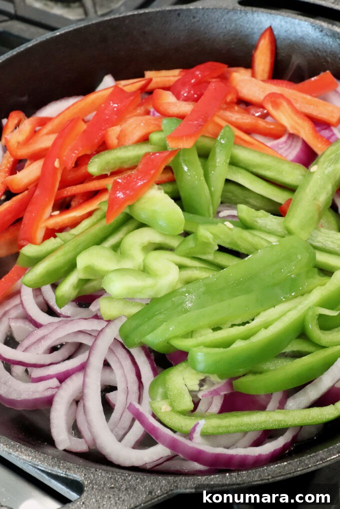 sliced bell peppers and onions in a skillet