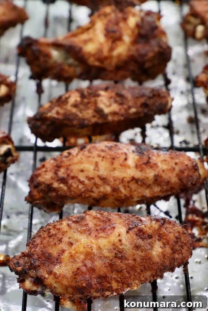 cooked, seasoned chicken wings on a wire rack on top of a baking sheet
