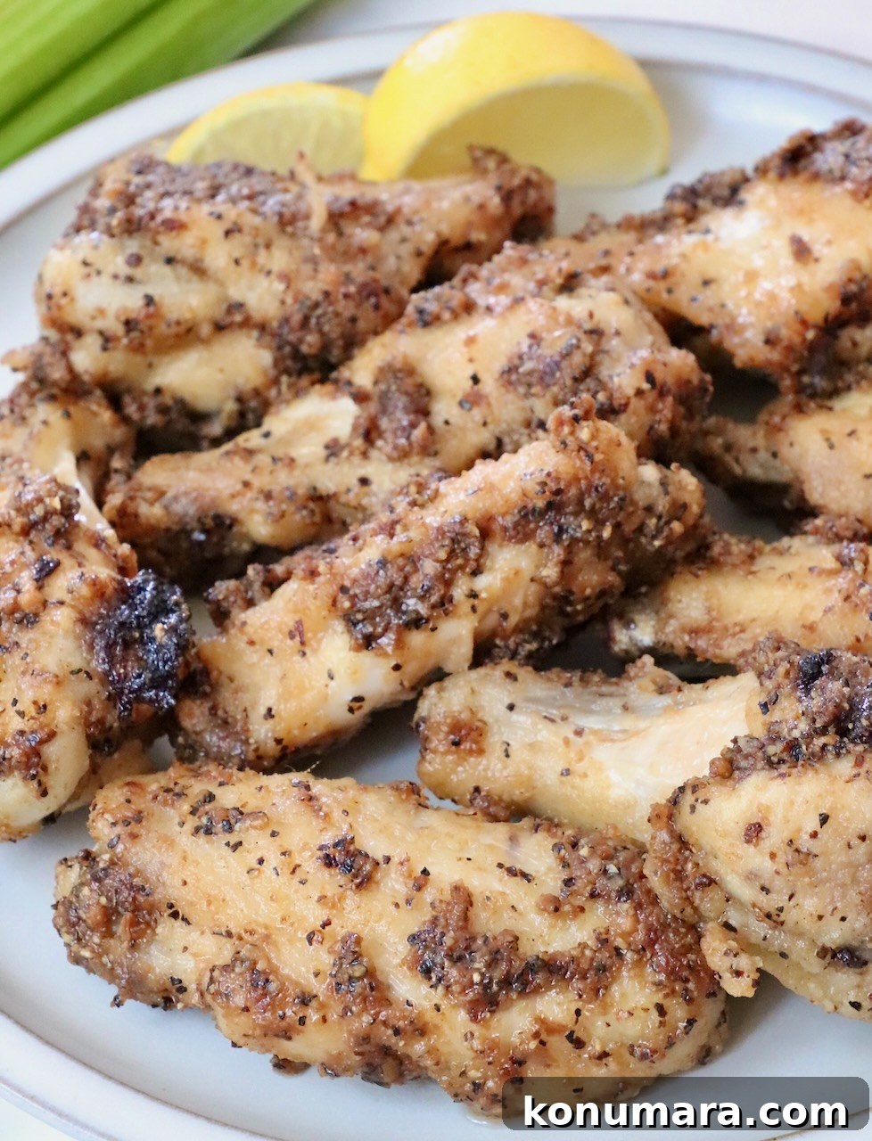 cooked wings tossed in lemon pepper sauce on a plate