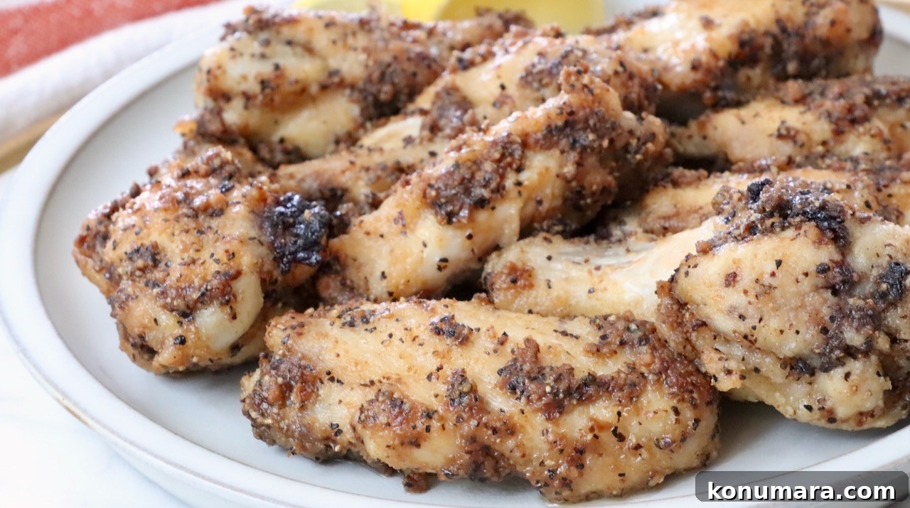 cooked lemon pepper wings stacked up on a plate