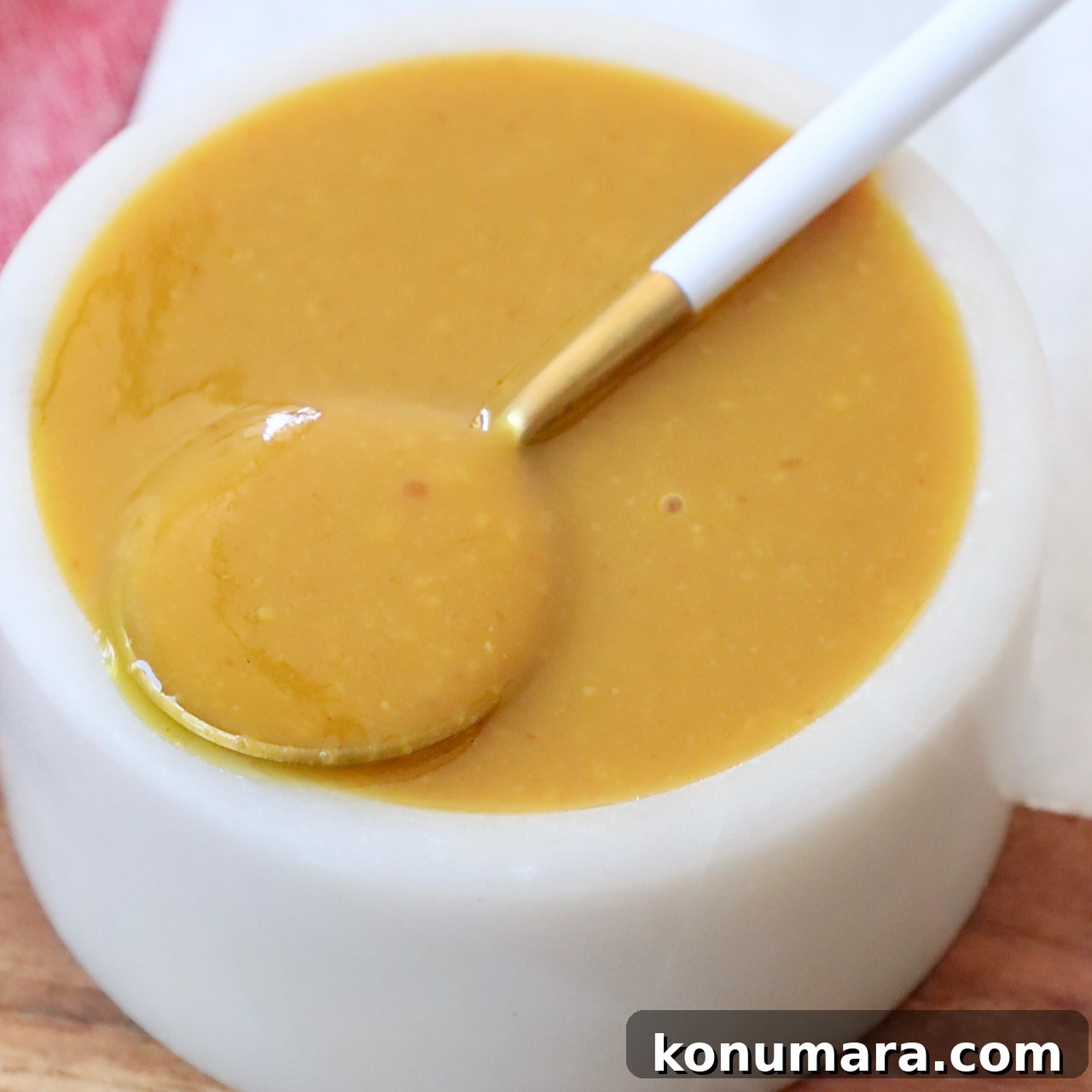 Carolina gold bbq sauce in small bowl with spoon