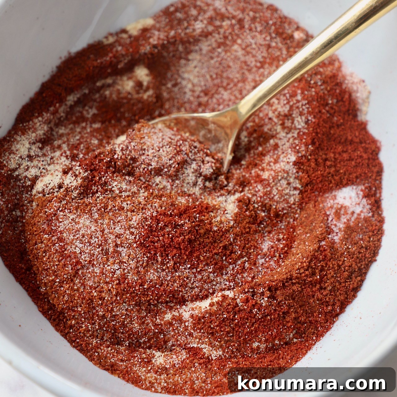chicken wing seasoning in white bowl with gold spoon