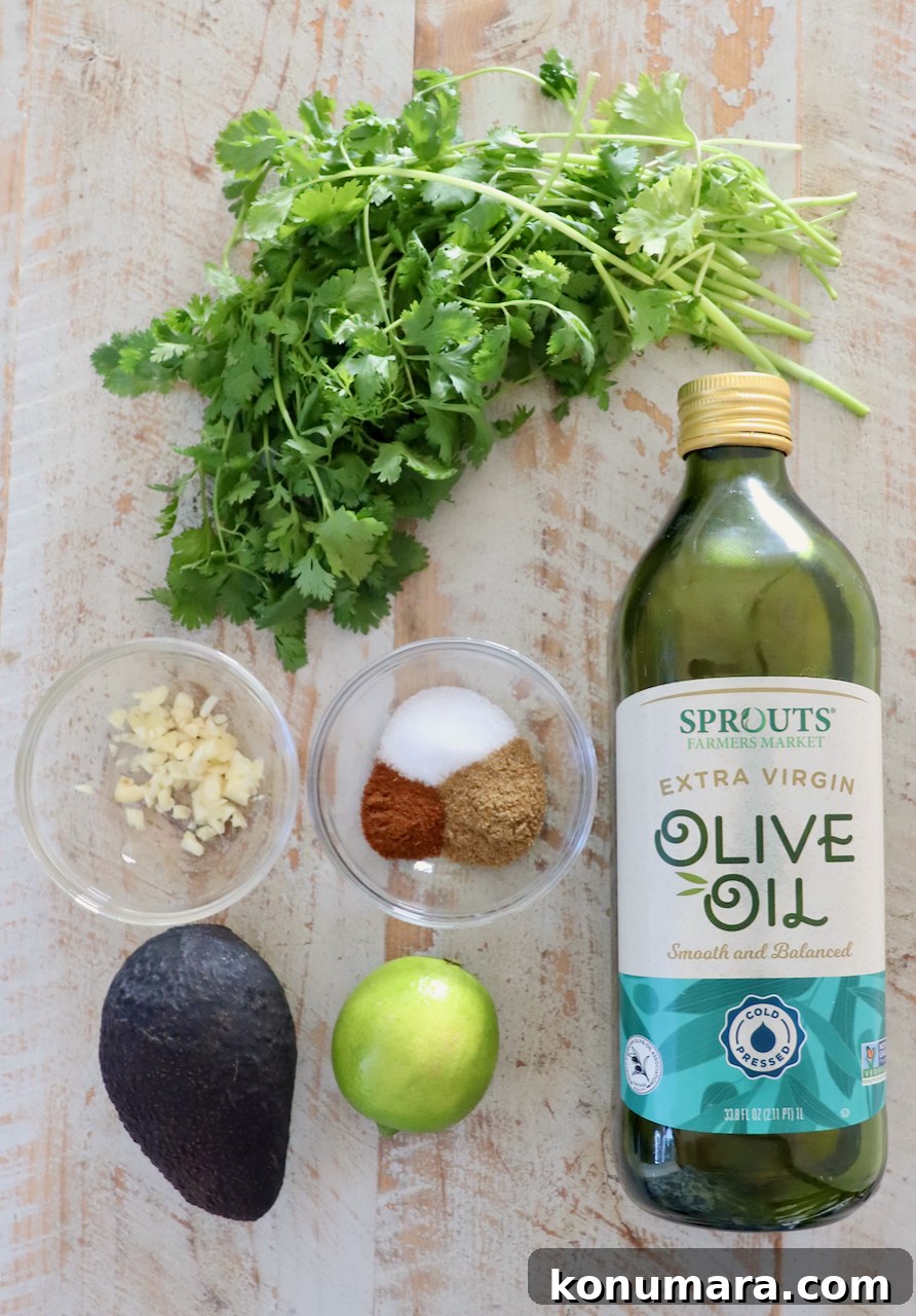 ingredients for avocado lime dressing on a white wood board