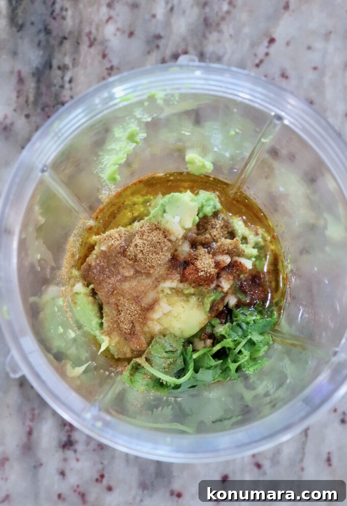 avocado, lime juice, cilantro and spices in a plastic blender cup