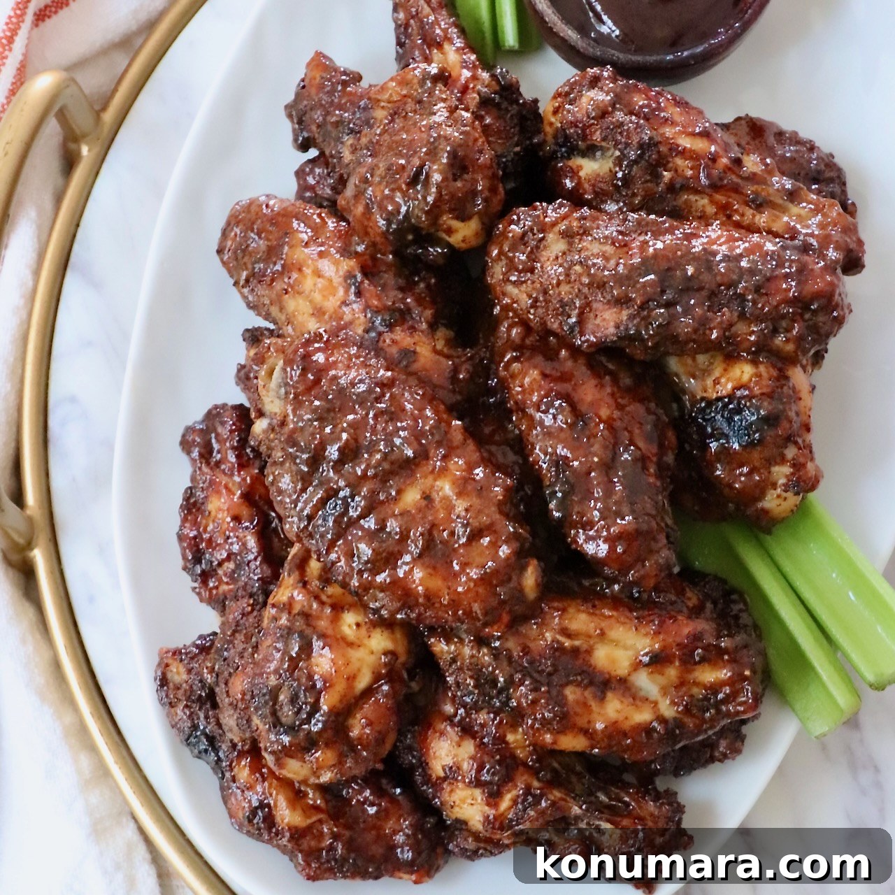 cooked chicken wings tossed in bbq sauce piled up on a plate