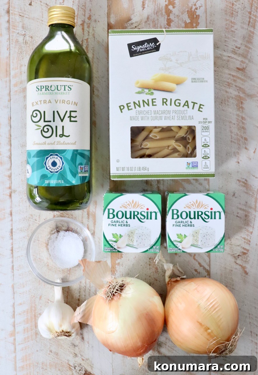 Ingredients on a wooden surface: olive oil, penne pasta, two packs of Boursin cheese, salt, garlic bulb, and two onions.