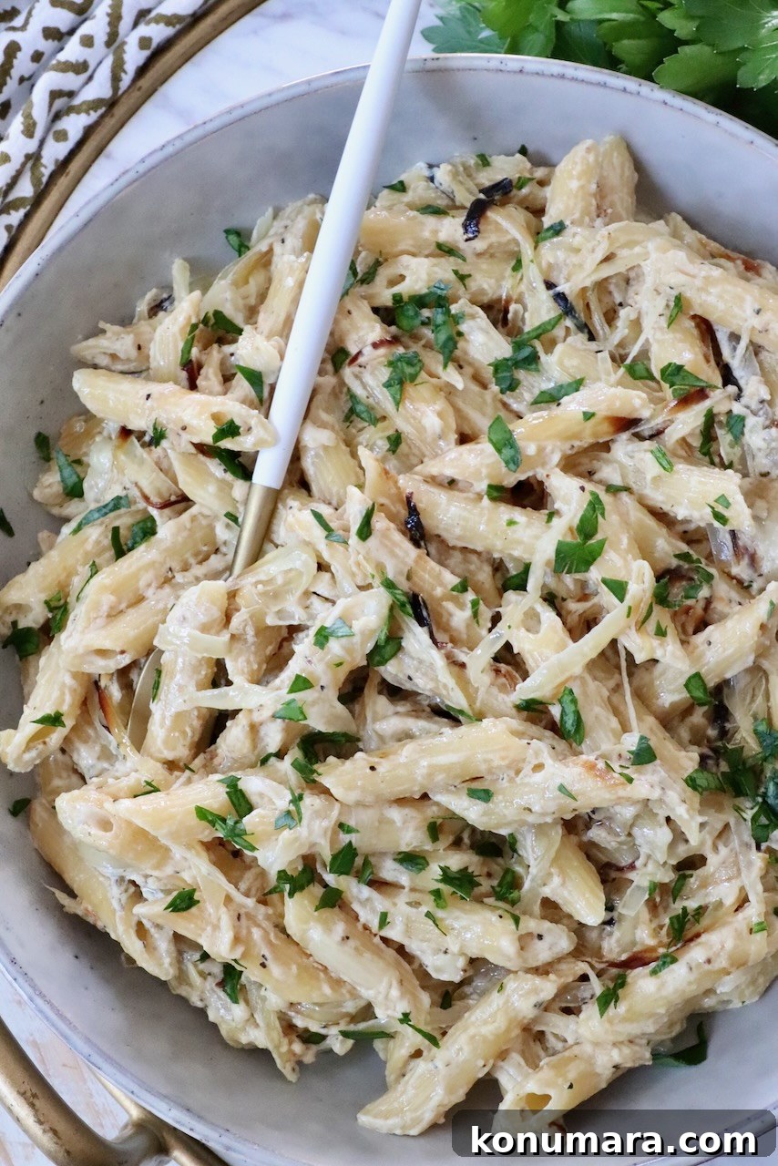 cooked penne pasta in a creamy sauce in a bowl with a fork