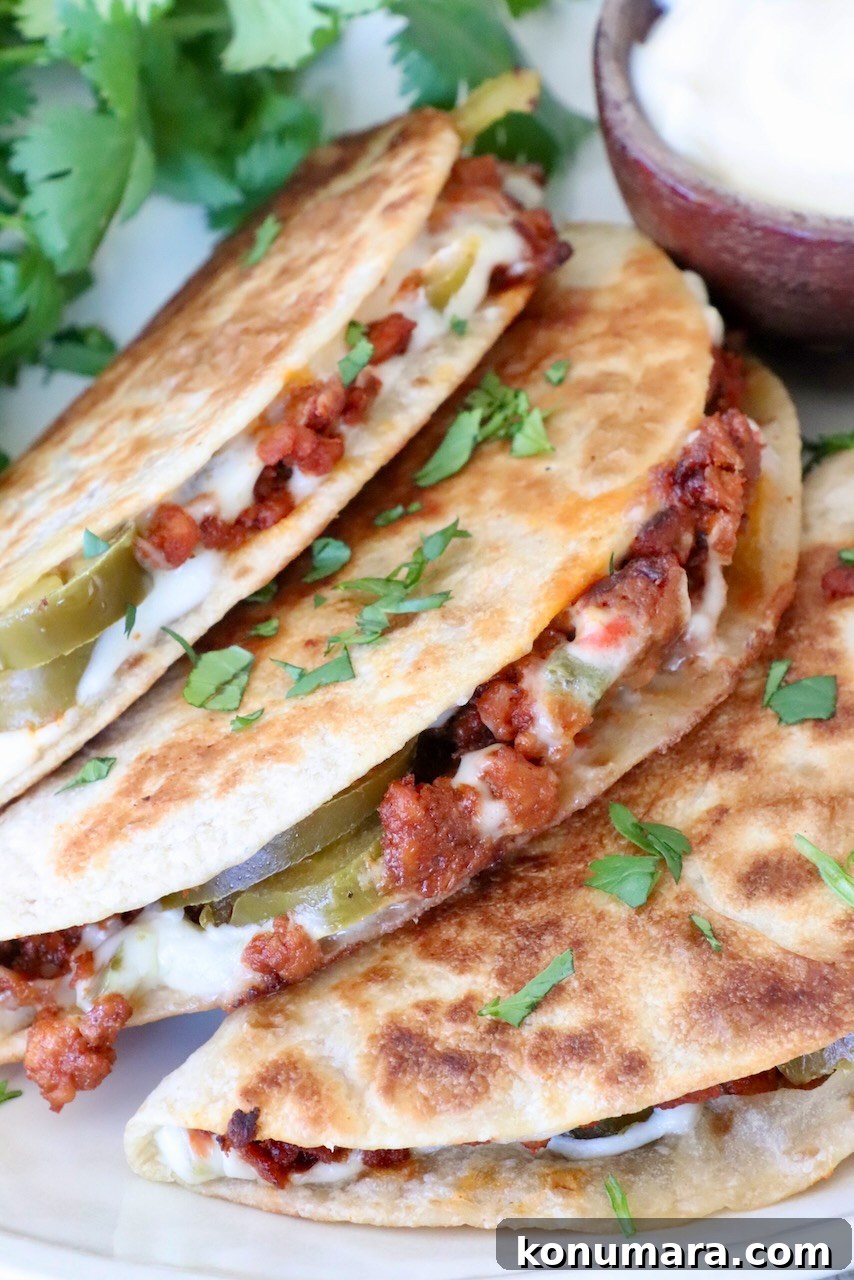 Crispy Chorizo Tacos with Melted Queso 10 Three crispy tacos filled with chorizo, cheese, and jalapeños are garnished with cilantro. A small bowl of white queso sits beside them.