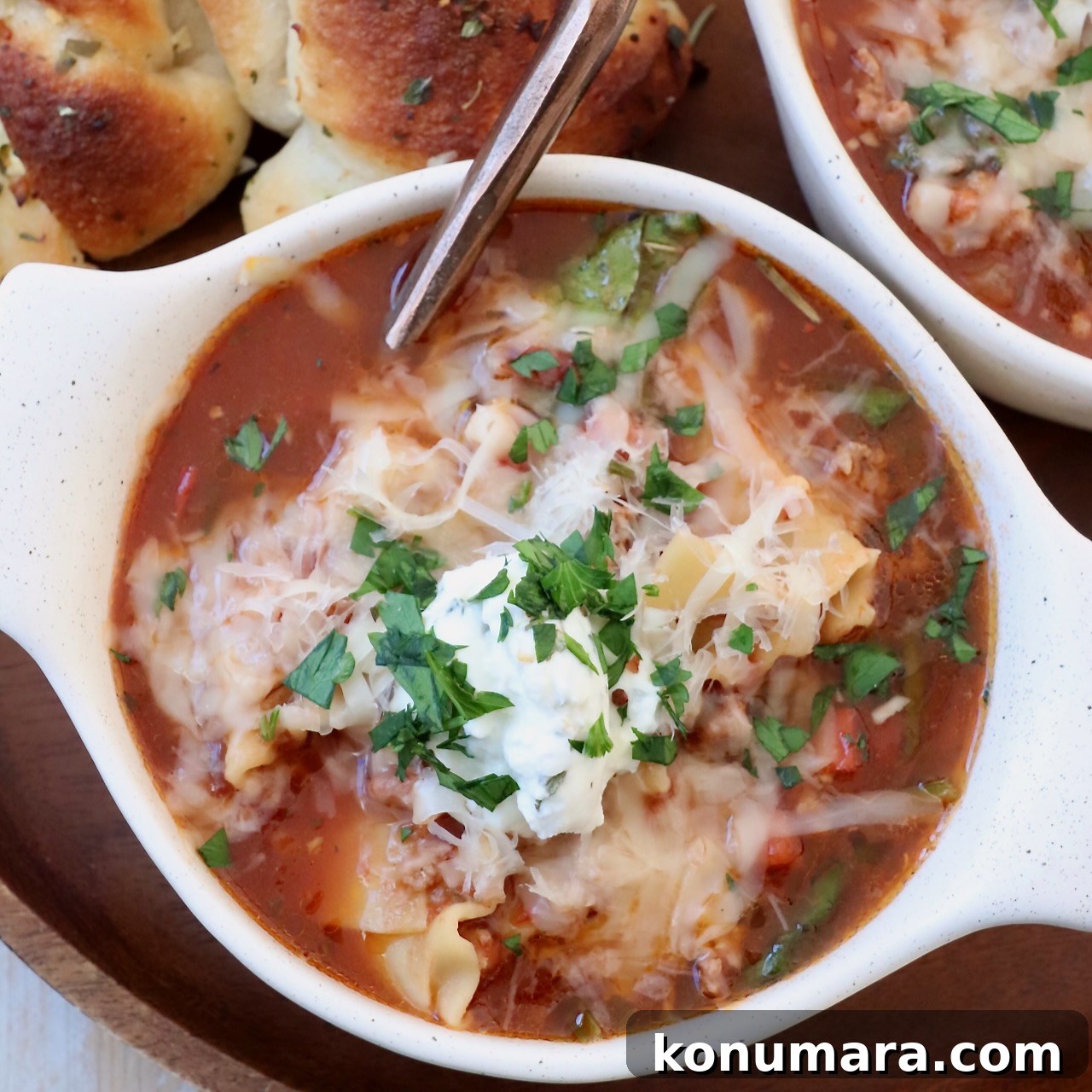 37 Cozy Fall Soup Recipes to Warm the Soul 7 lasagna soup, topped with cheese, in bowl with spoon