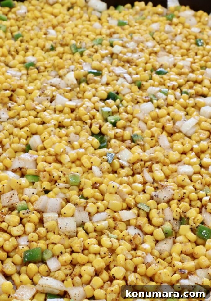 Mexican Street Corn Soup Recipe (Elote-Inspired) 5 seasoned kernels of corn mixed with diced onions, jalapenos and garlic cloves on a baking sheet