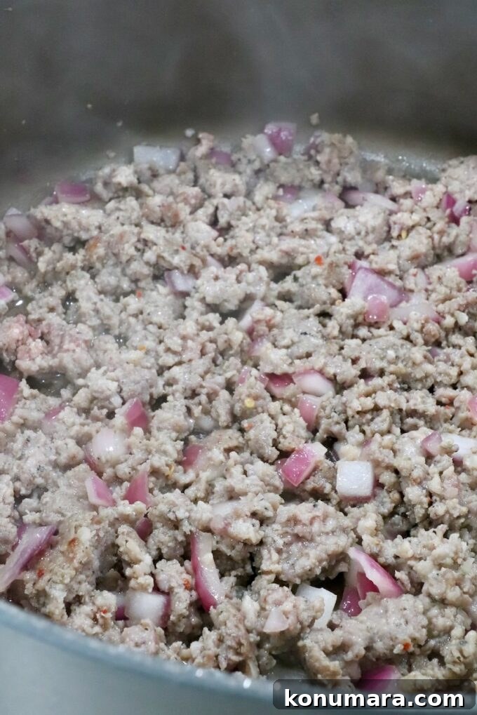Sheet-Pan Butternut Squash Lasagna Recipe 7 cooked, crumbled sausage in a pan with diced onions