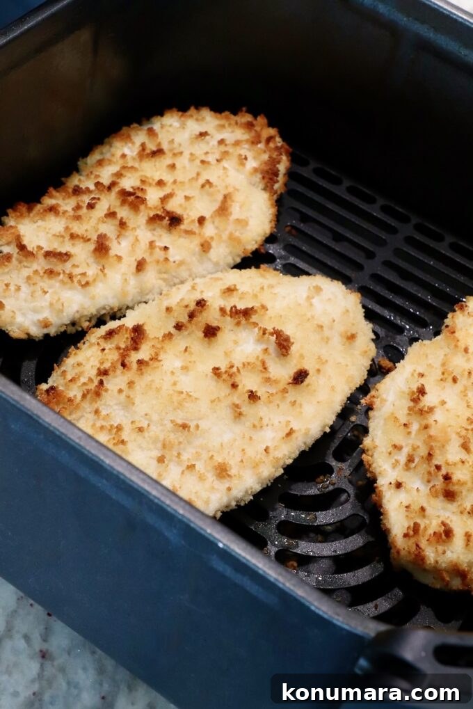 Crispy Garlic Chicken Topped with Tomato Basil Bruschetta 7 cooked crispy chicken breasts coated in breadcrumbs in an air fryer basket