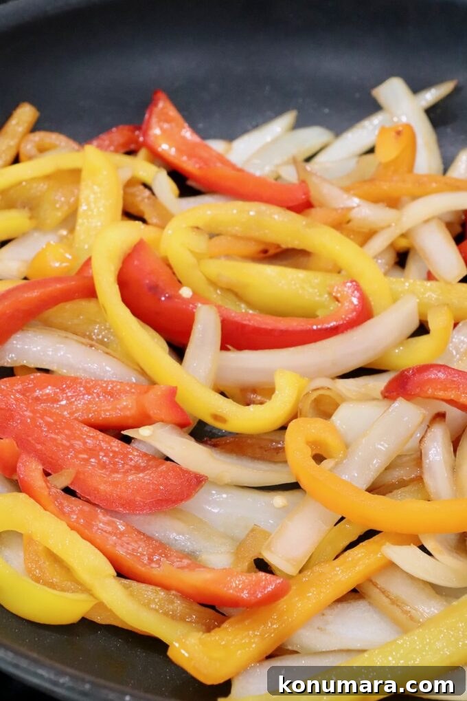 cooked, sliced peppers and onions in a skillet