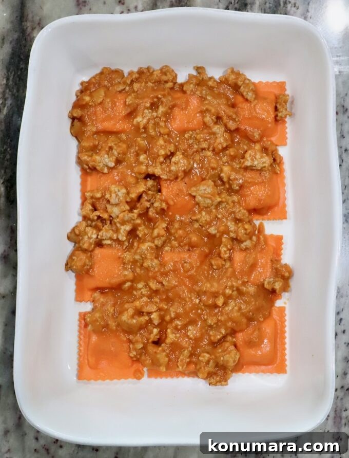Baked Butternut Squash Ravioli with Brown Butter and Sage 7 pumpkin ravioli in a baking dish, topped with butternut squash meat sauce