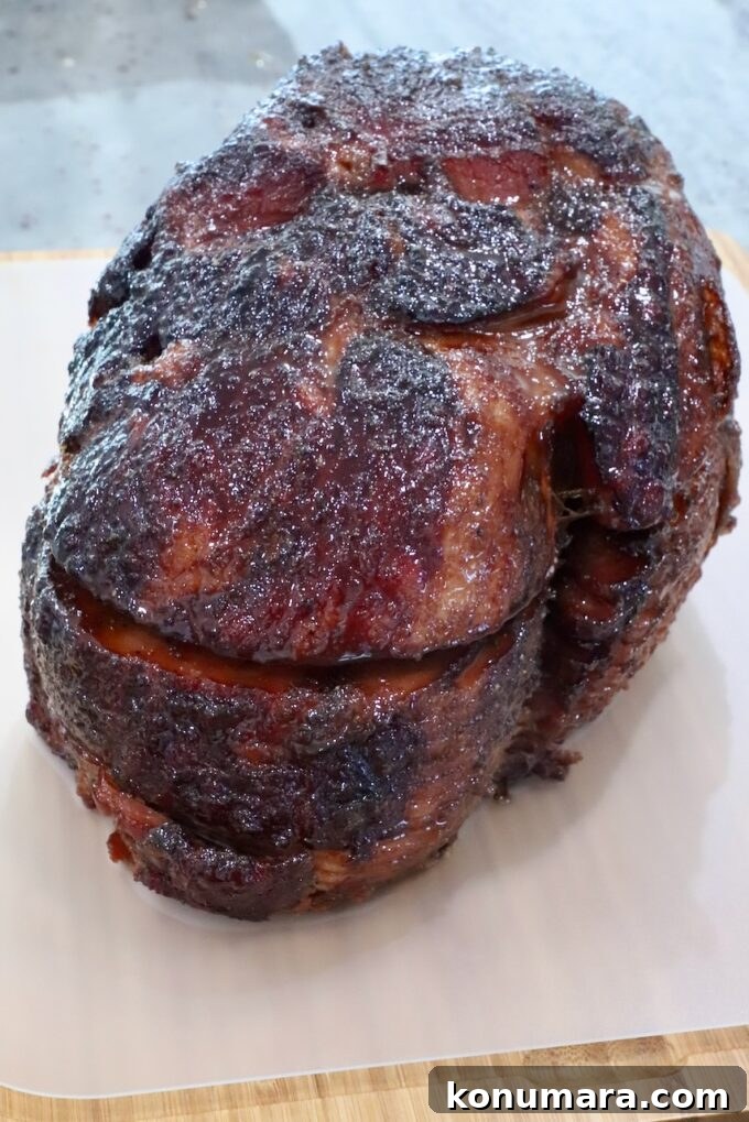 How to Smoke a Ham: Glaze, Time, and Temperature 11 Close-up of a glazed, roasted ham on a wooden board. The ham's exterior is caramelized and crispy