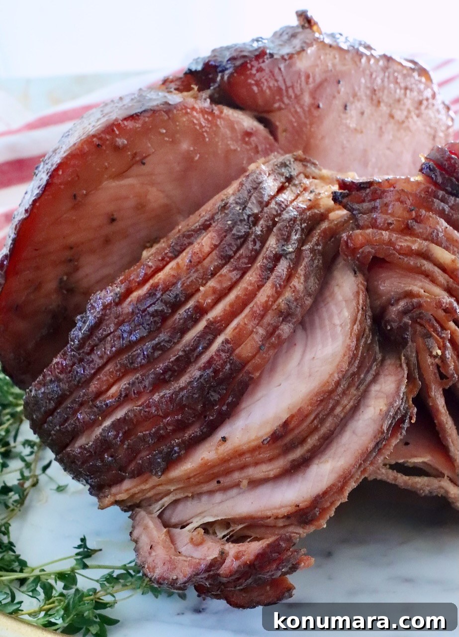 How to Smoke a Ham: Glaze, Time, and Temperature 12 Sliced, glazed ham on a white platter with fresh thyme