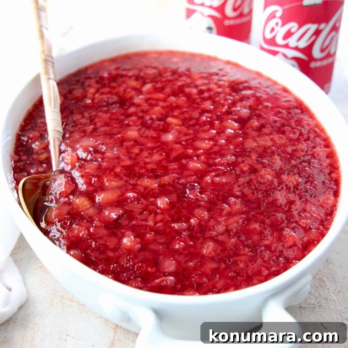 cherry jello salad in white serving bowl with spoon
