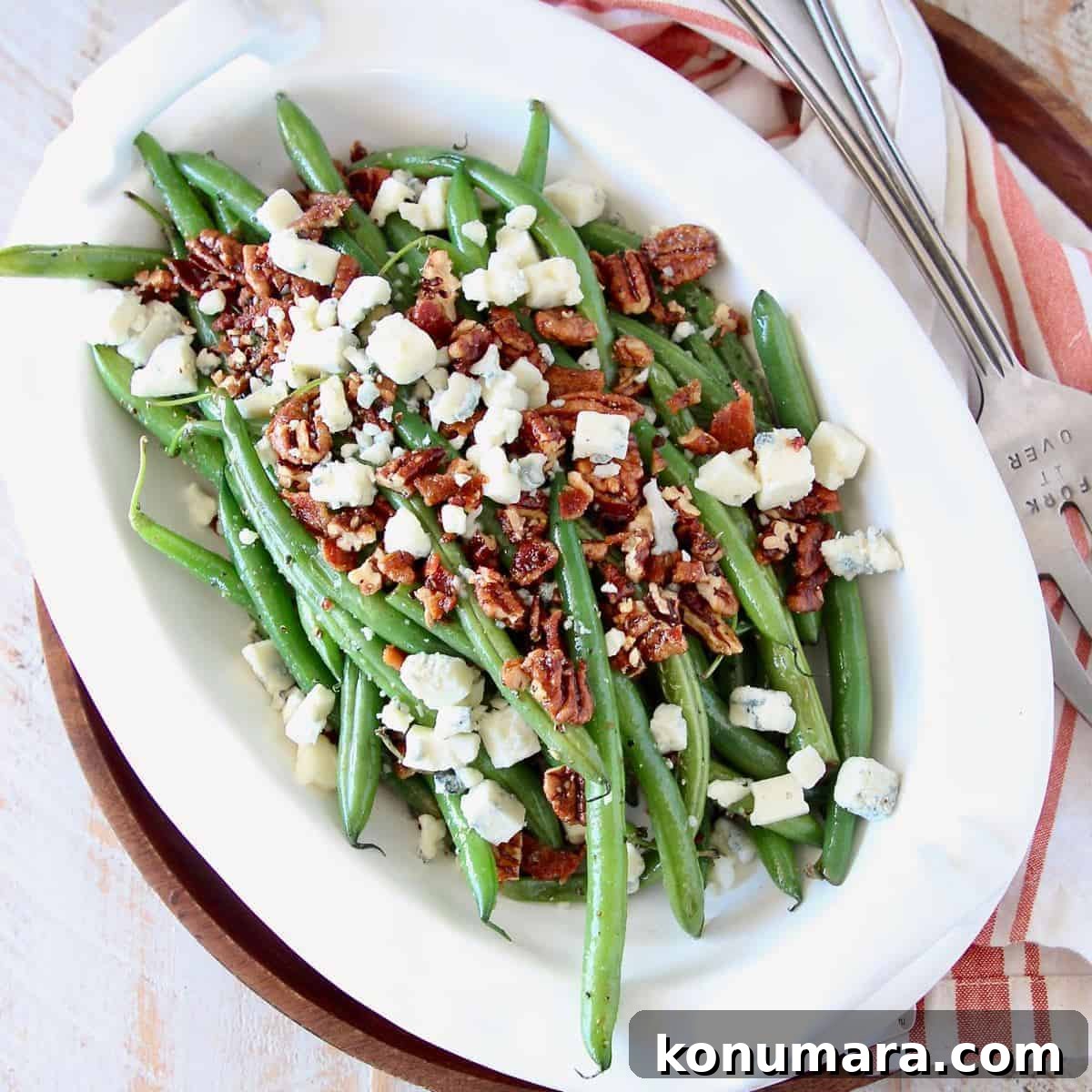 fresh green beans in serving bowl with pecans and blue cheese