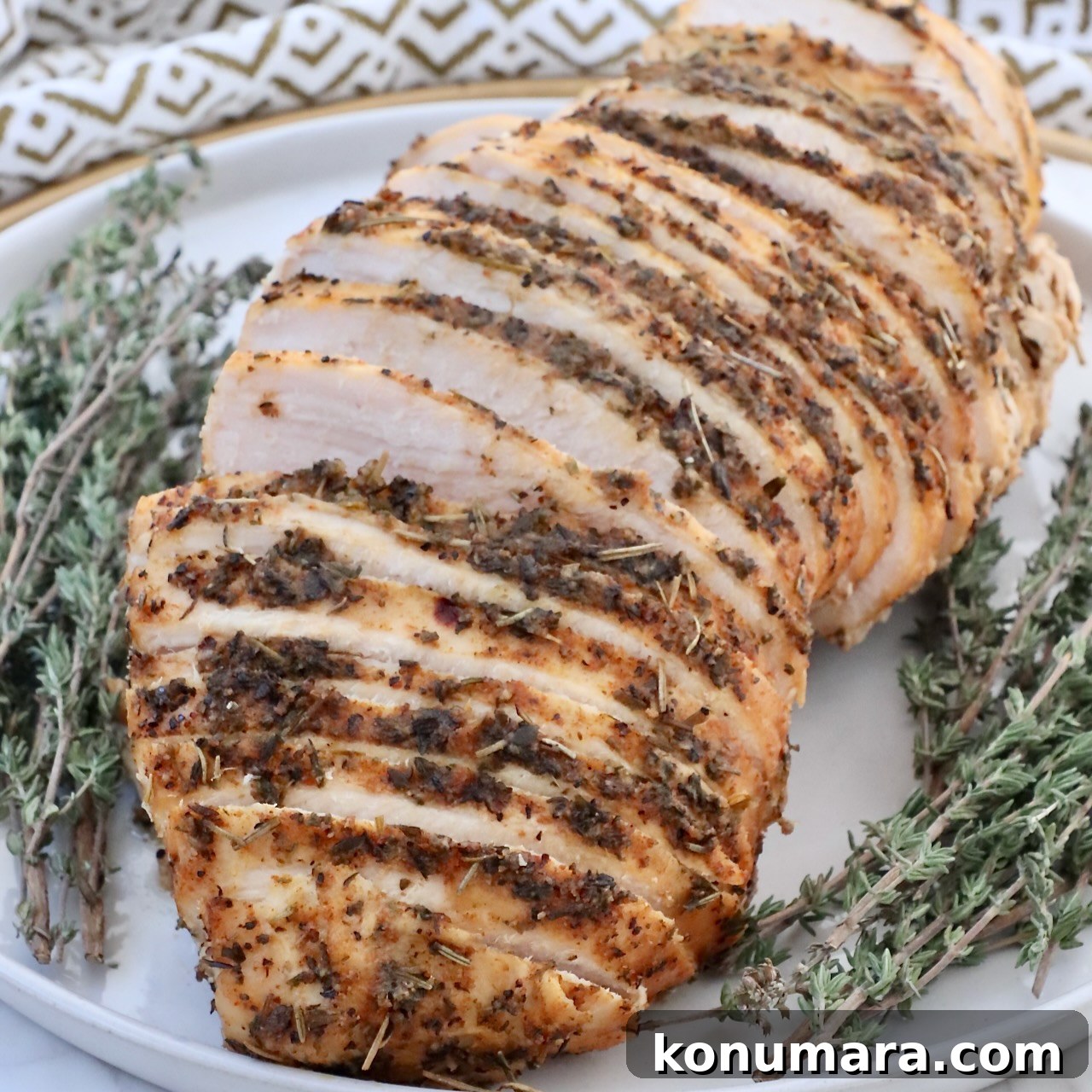 sliced turkey breast on a plate with fresh thyme
