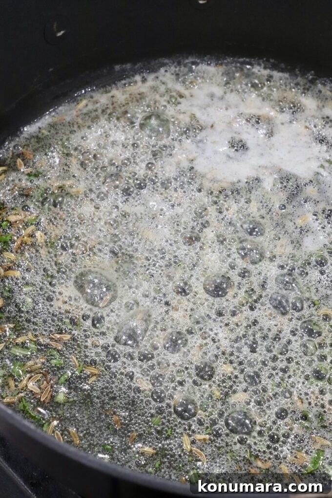 Sirloin Tip Roast Recipe for Tender, Juicy Results 5 Close-up of seeds and herbs simmering in a bubbling, frothy liquid in a black pot