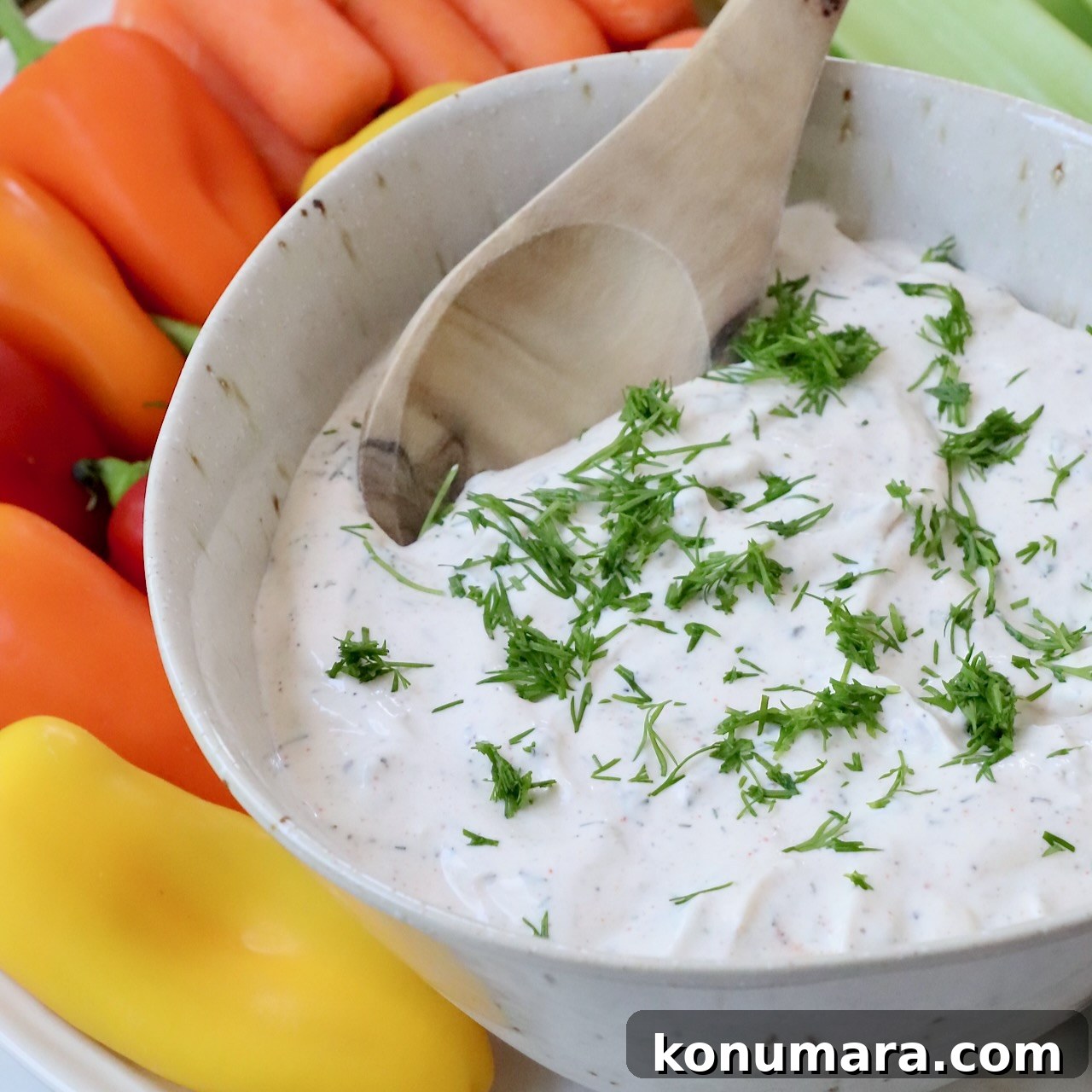 creamy vegetable dip in bowl topped with fresh chopped dill