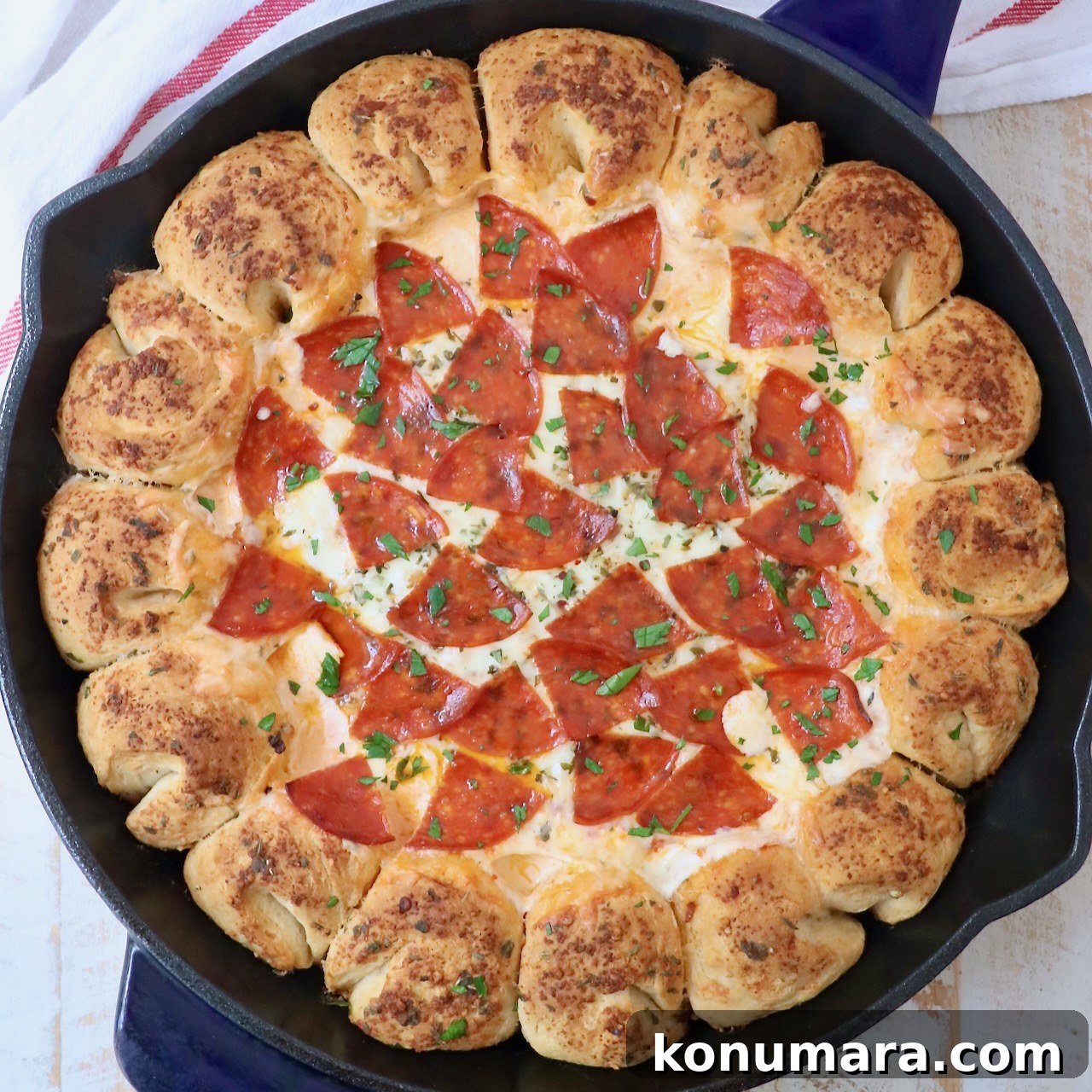 pizza dip in a skillet with pull apart bread surrounding the dip