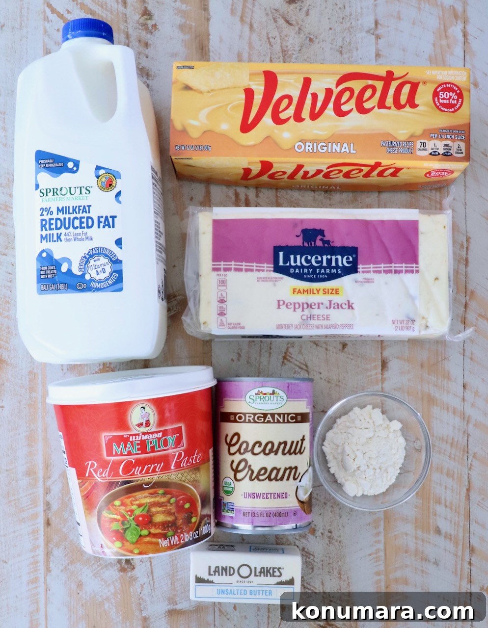 Curry Queso Dip Recipe 3 Flat lay of ingredients for curry queso: milk, Velveeta, pepper jack, red curry paste, coconut cream, flour, butter