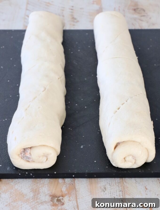 rolled up crescent roll dough on a cutting board